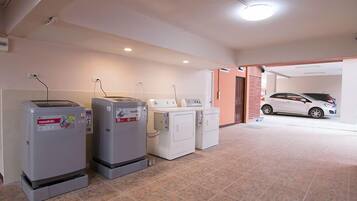 A laundry room with a washing machine, dryer, and stacked laundry baskets.