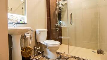 A modern bathroom with a glass-enclosed shower, a white toilet, and a sink.