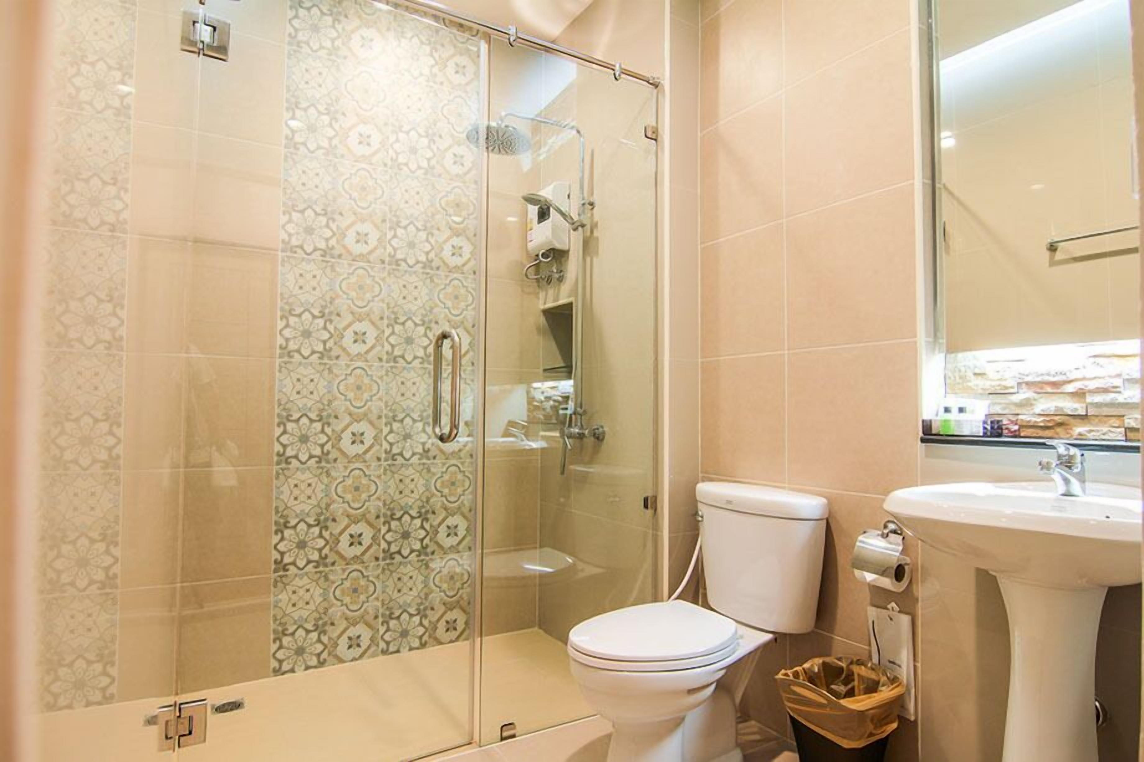 Un baño con ducha de vidrio, inodoro y lavamanos.