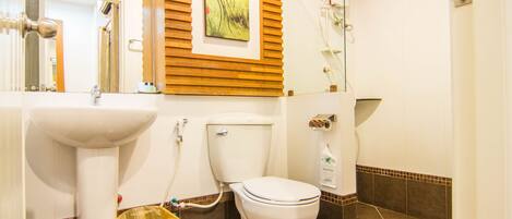 Un baño con inodoro, lavabo y ducha.