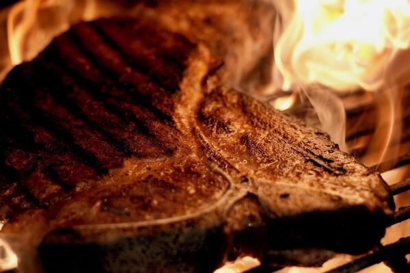 Ein Nahaufnahme eines gegrillten Steaks mit deutlichen Grillstreifen, was darauf hindeutet, dass es über offenem Feuer gegart wurde.
