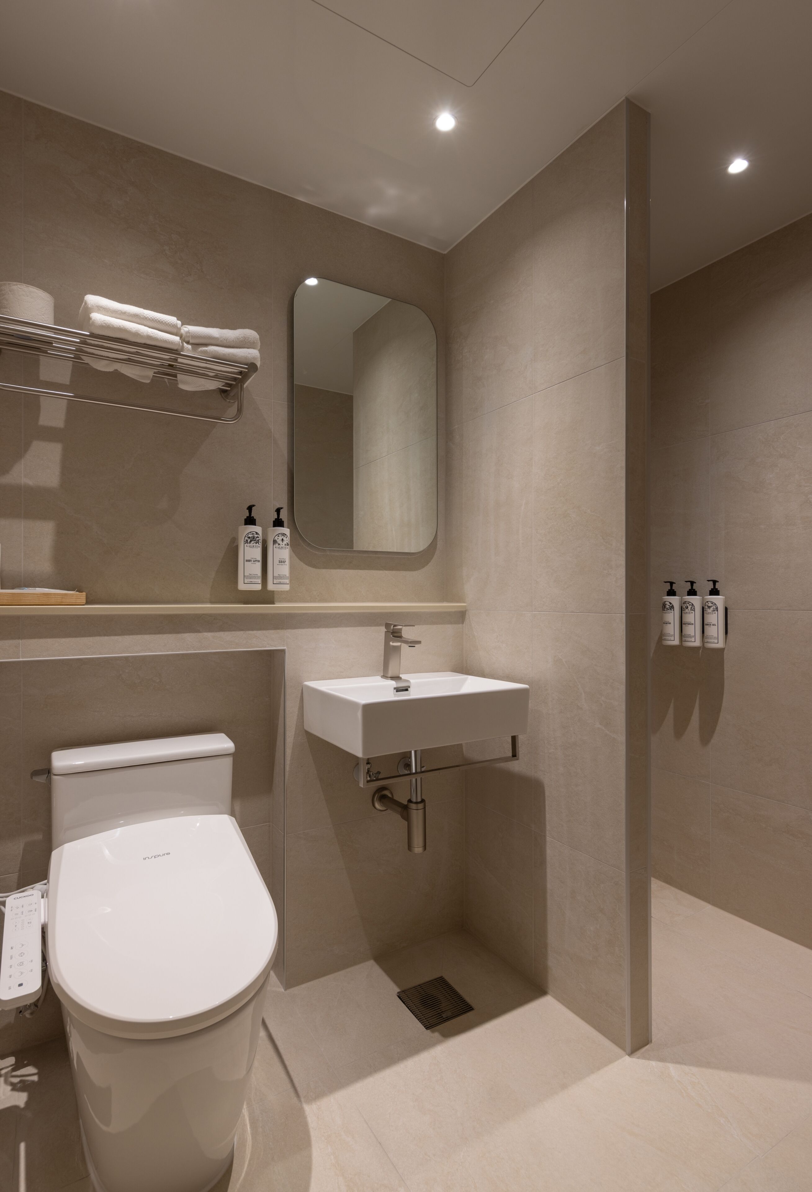A modern bathroom with a toilet, sink, and shower.