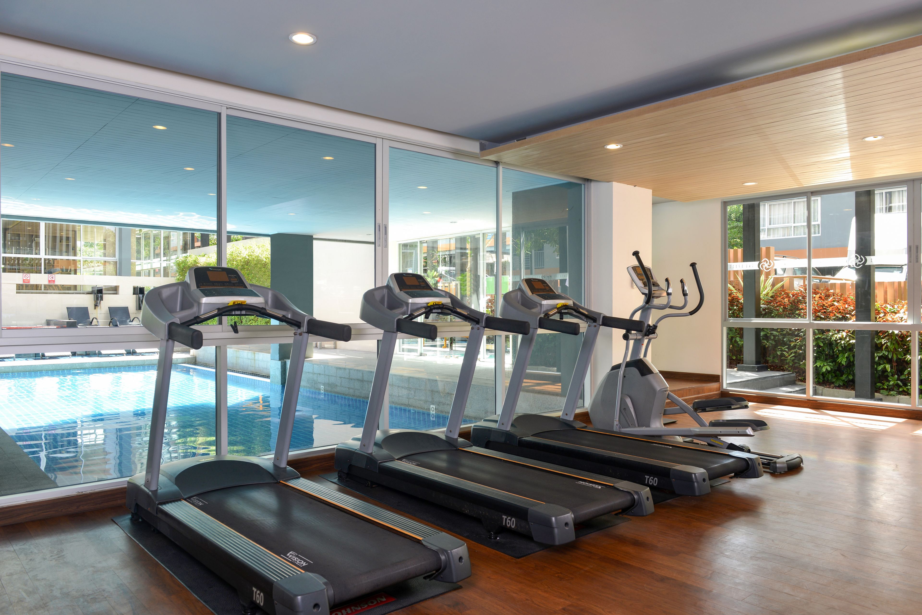 A gym with treadmills and a pool.
