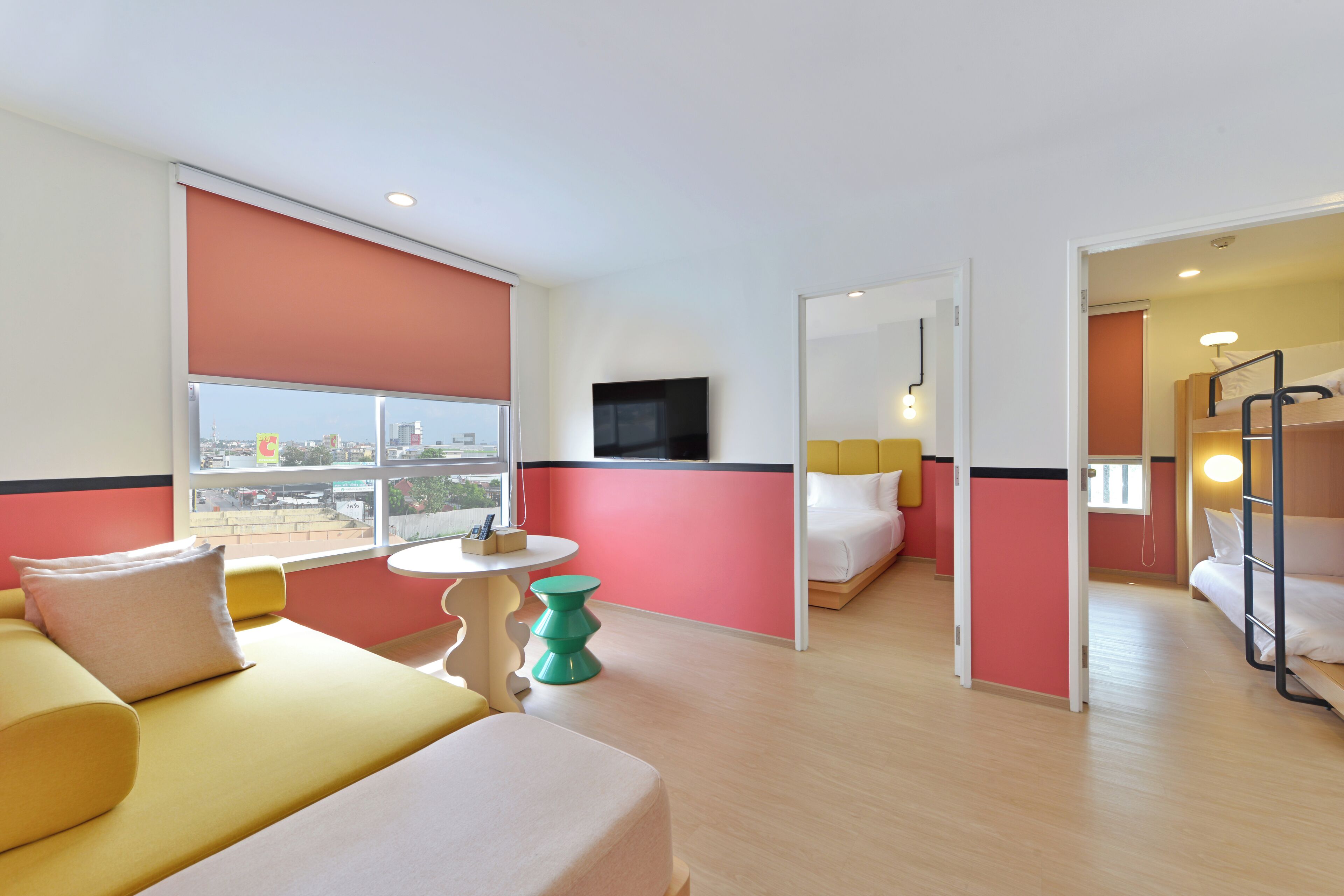 A hotel room with a bed, a sofa, a small table, and a TV.