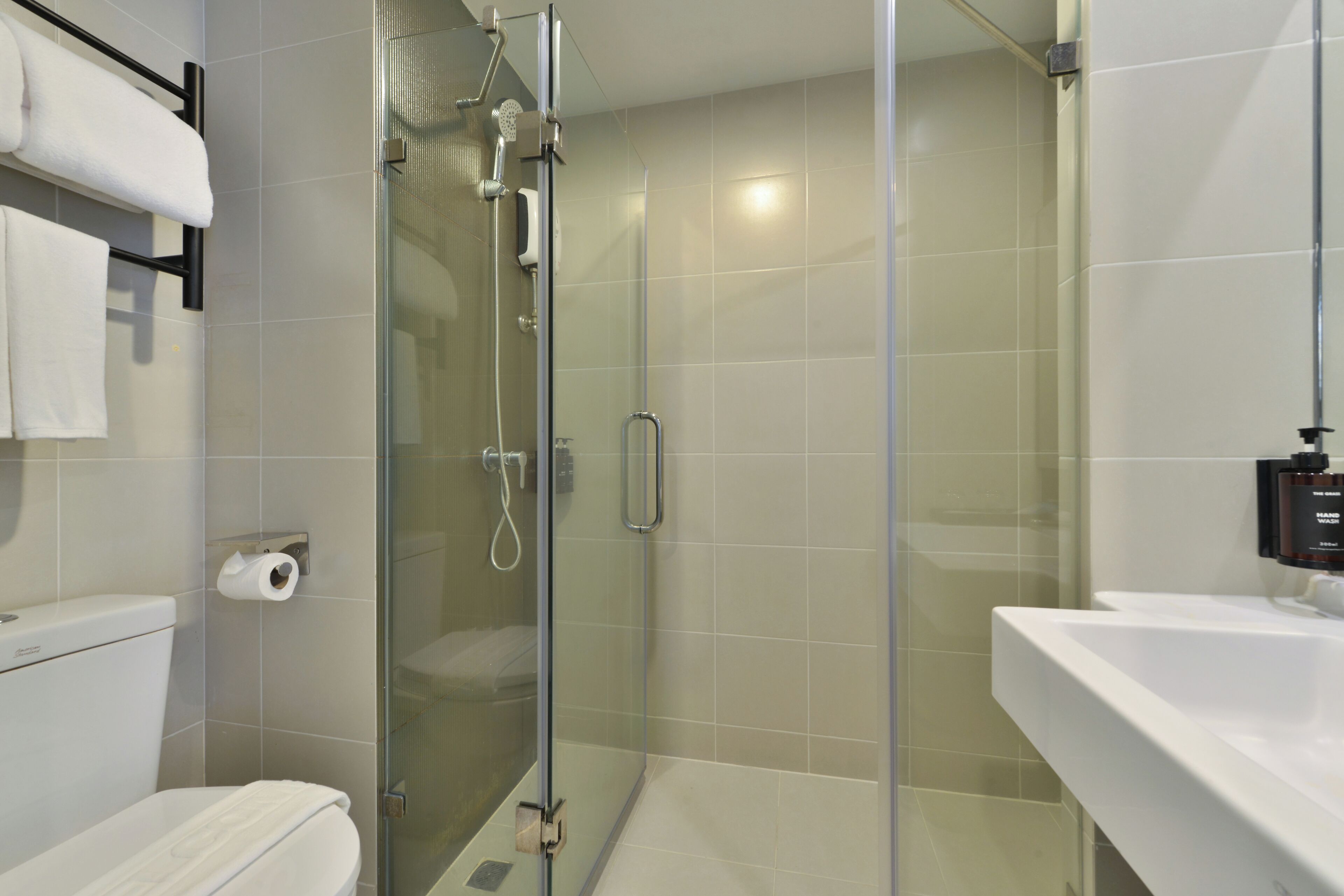 Une salle de bain moderne avec une douche à parois de verre, des toilettes et un lavabo.