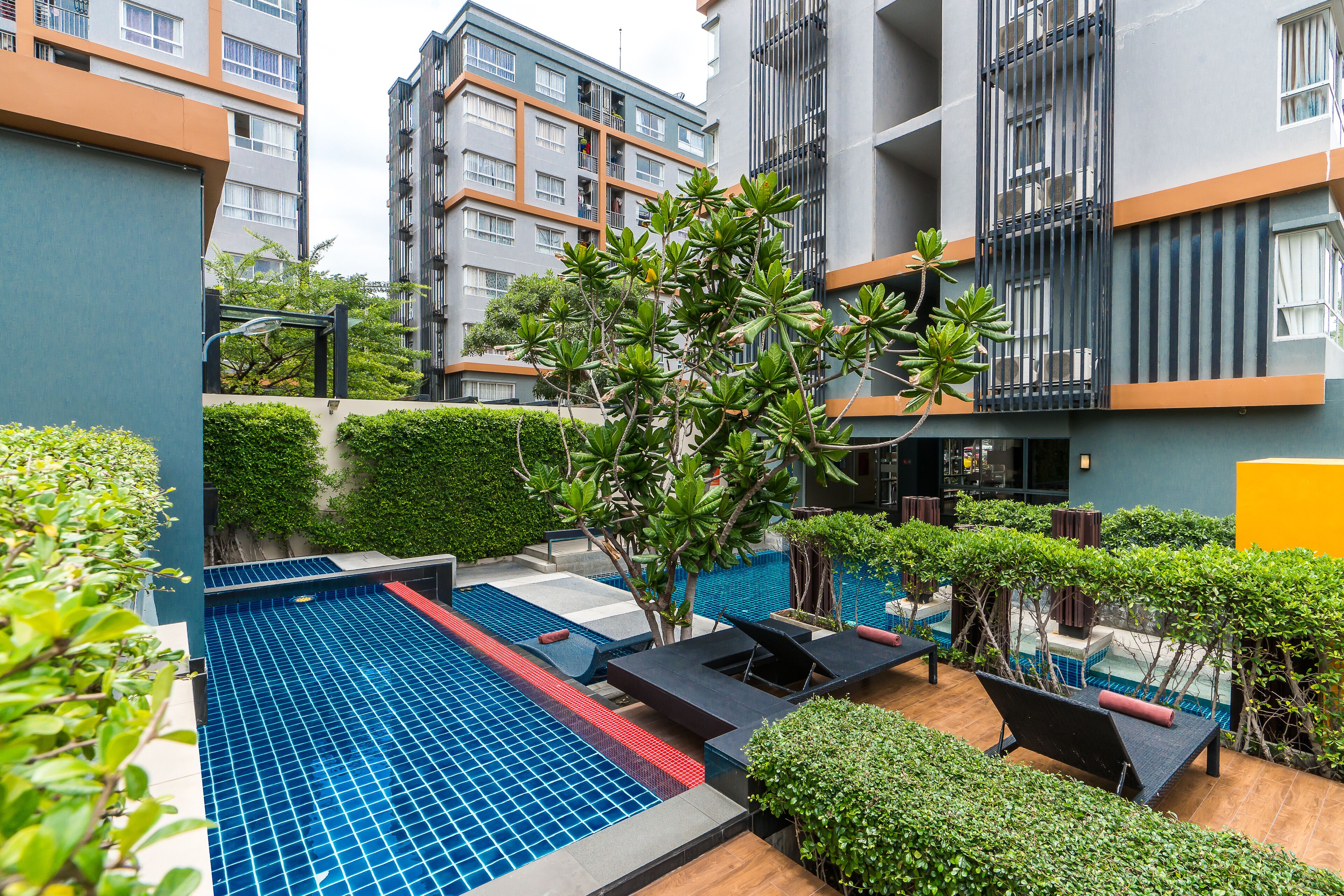 A rooftop pool area with lounge chairs and a small waterfall feature.