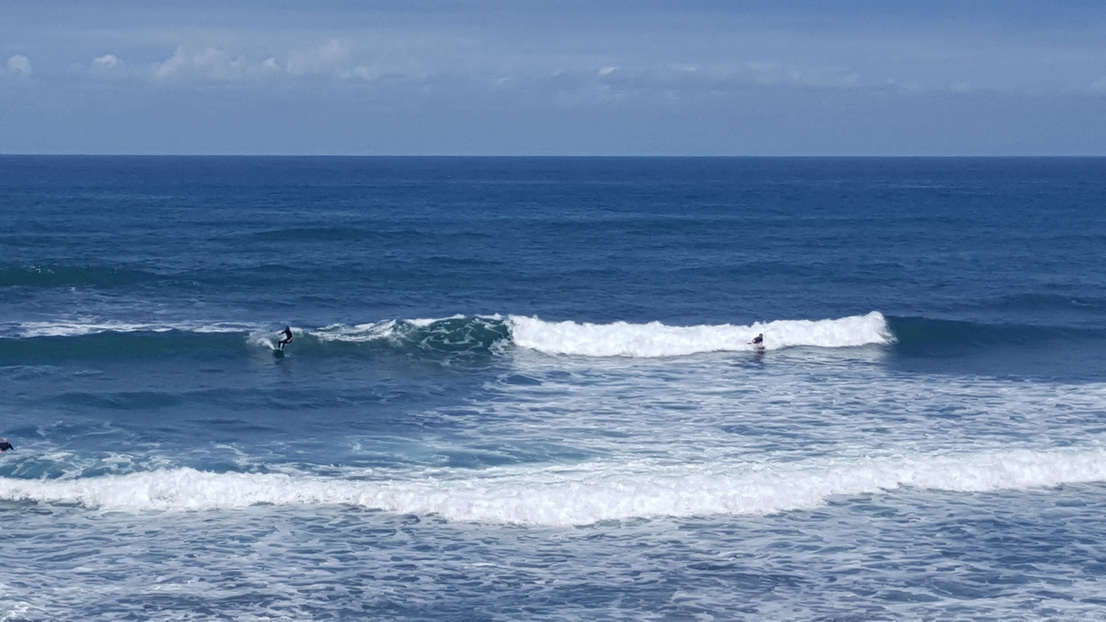 A coastal scene with waves and surfers.