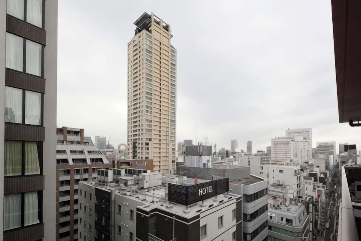 A hotel with a rooftop terrace, surrounded by high-rise buildings.