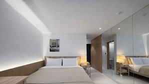 A modern hotel room with a large bed, bedside tables, a mirror, and a view of the outside. - JEJU DSPHERE HOTEL (Jeju City)