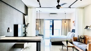 A modern hotel room with a kitchen area, a dining table, a sofa, and a bed. - Summer Suites Vacation Home (Kuala Lumpur)