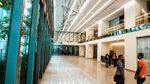 A spacious, modern lobby with a high ceiling, reflective floors, and a mix of glass and metal railings. - Summer Suites Vacation Home (Kuala Lumpur)
