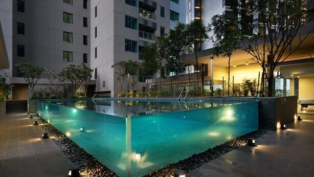 A rectangular pool with a clear blue water surface, surrounded by a pebble border and small lights. - Summer Suites Vacation Home (Kuala Lumpur)