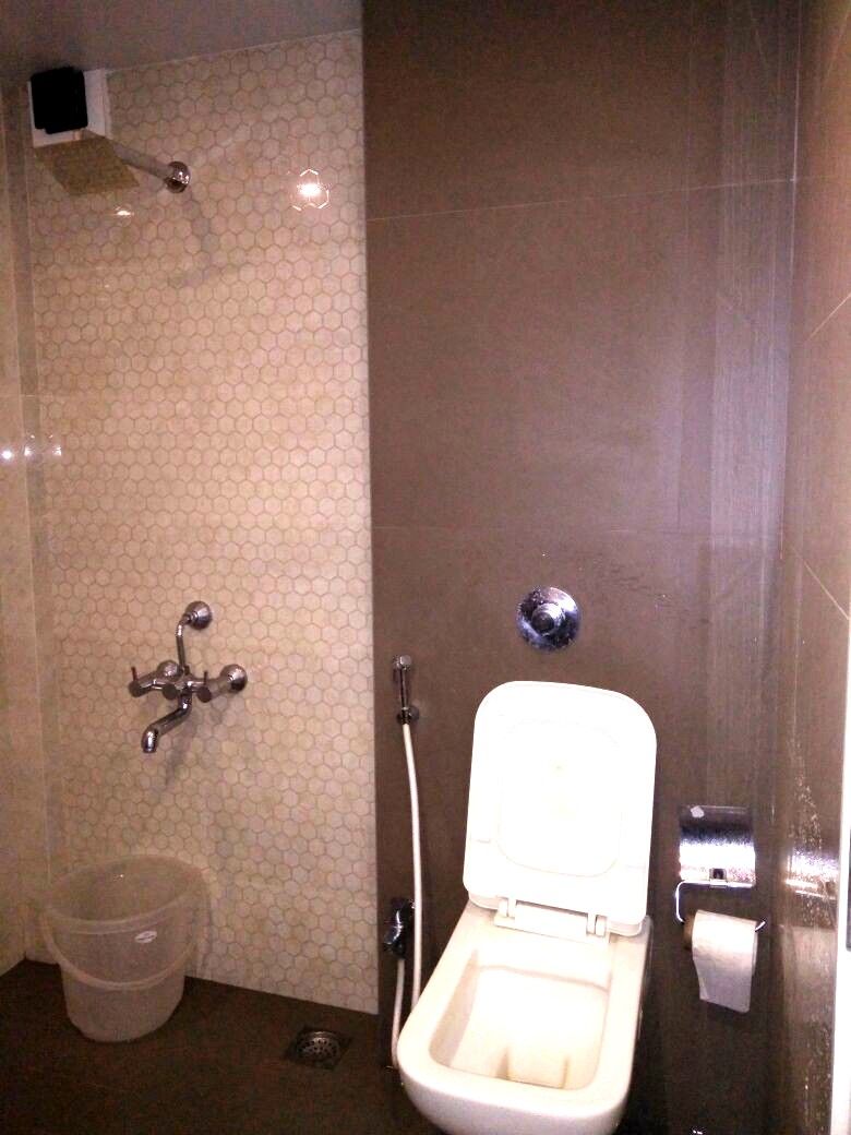 A small bathroom with a toilet, a shower, and a sink.
