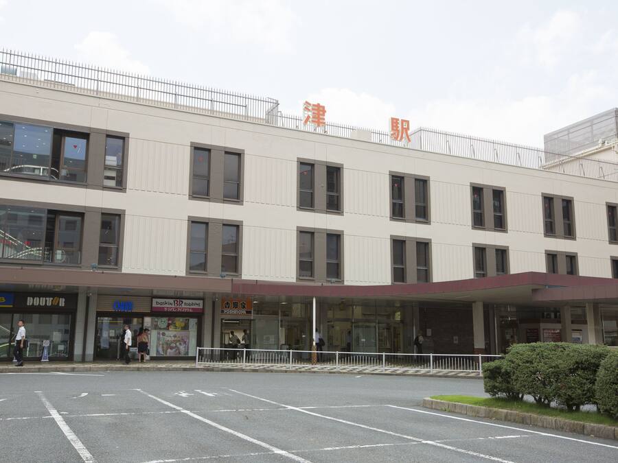 A multi-story building with a flat facade, large windows, and a sign with Chinese characters.