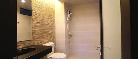 Une salle de bain moderne équipée d’une douche, de toilettes et d’un lavabo.