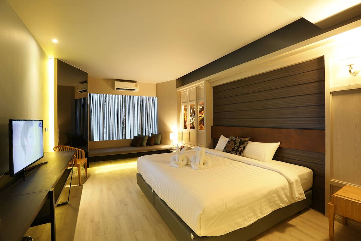 A modern hotel room with a large bed, a desk, and a television.