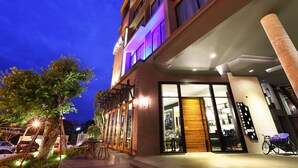 A modern hotel with a glass facade, outdoor seating, and a visible restaurant. - Hatyai Signature Hotel (Hat Yai)