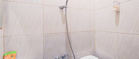 A bathroom with a shower, toilet, and a sink.