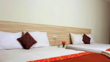 A hotel room with two beds, each with white bedding and a red decorative border.