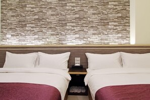 A hotel room with two beds, a stone wall, wooden headboard, and a nightstand with a tissue box. - Blue Ocean Stars B&B (Taitung)