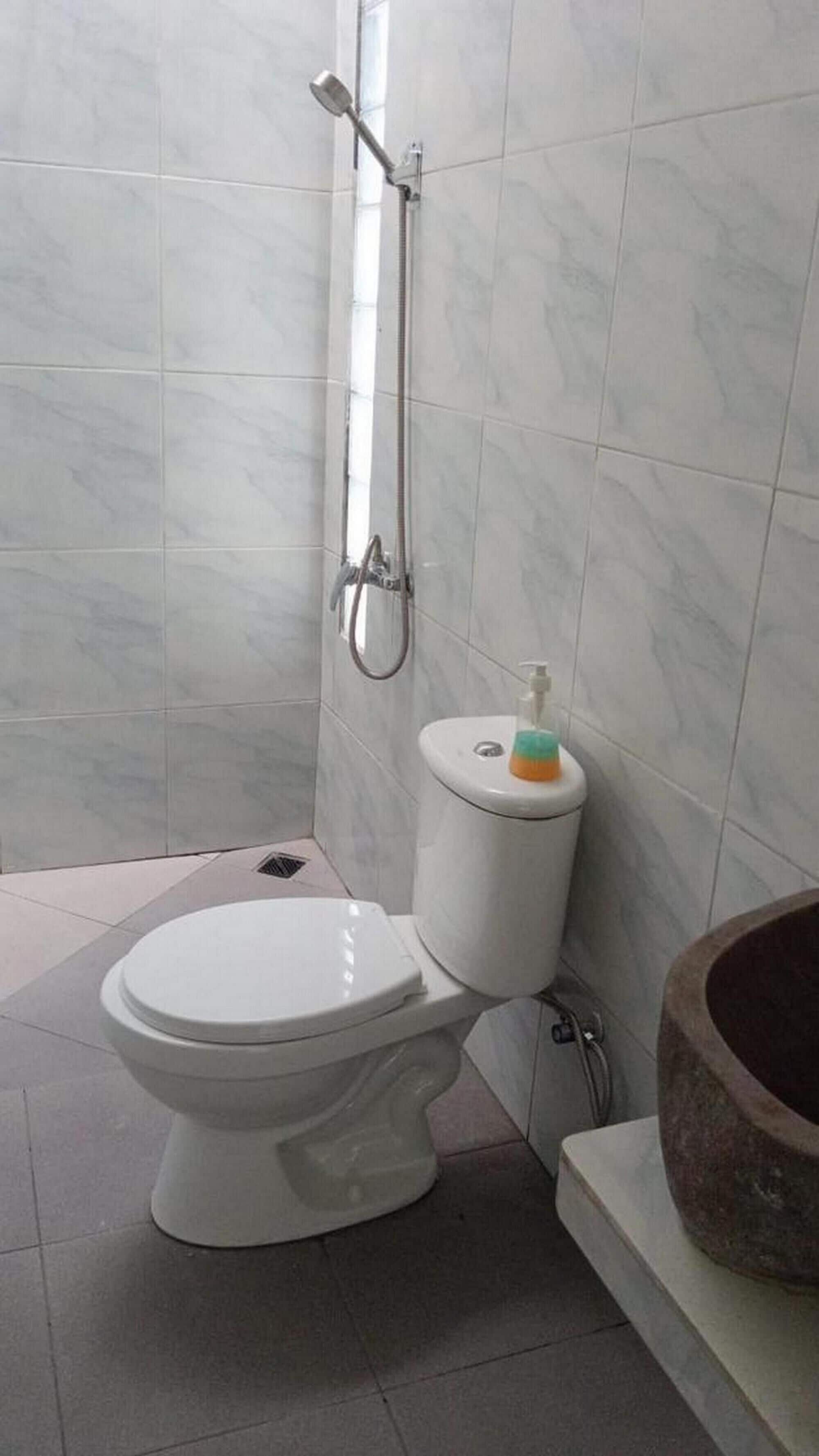 Een badkamer met toilet, douche en wastafel.