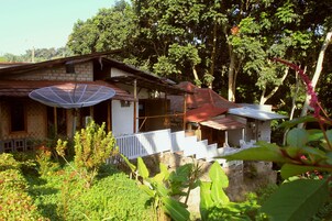 Una casa con antena parabólica, un porche y un jardín.