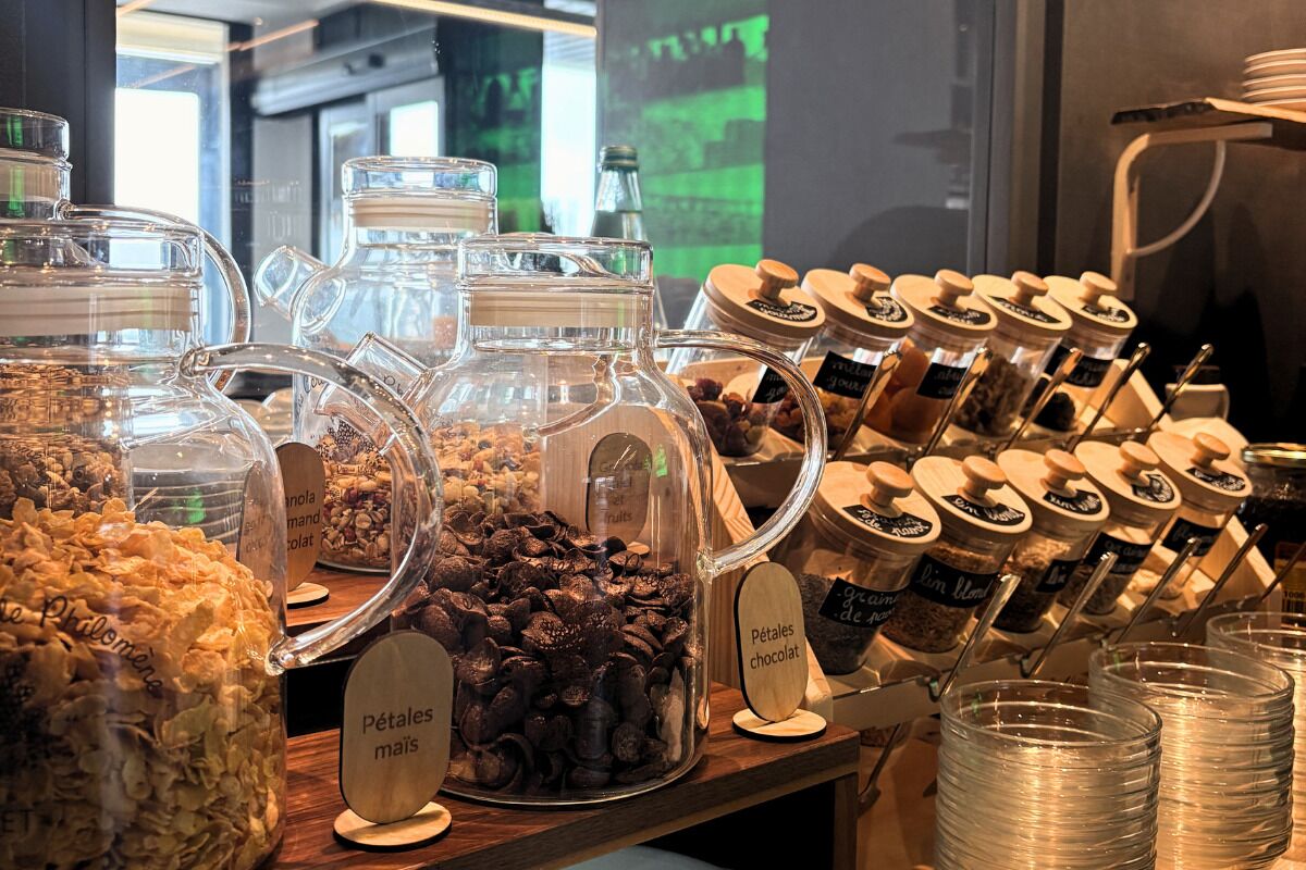 Exposição de alimentos com vários potes etiquetados com itens alimentares como 'Pétales chocolat' e 'Pétales mais'.