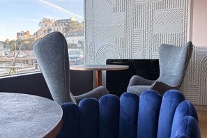 Ein modernes Interieur mit einem runden Tisch, einem blauen Stuhl und einer Wand mit Muster.