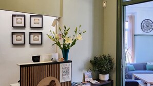 En reception med trædesign, en hængende lampe, indrammet kunst på væggen og en potteplante.