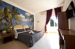 A bedroom with a bed, a desk, a TV, and a mural of palm trees. - Maikol Family Guesthouse (Rome)