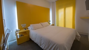 Een hotelkamer met een groot bed, een nachtkastje en een kledingkast.