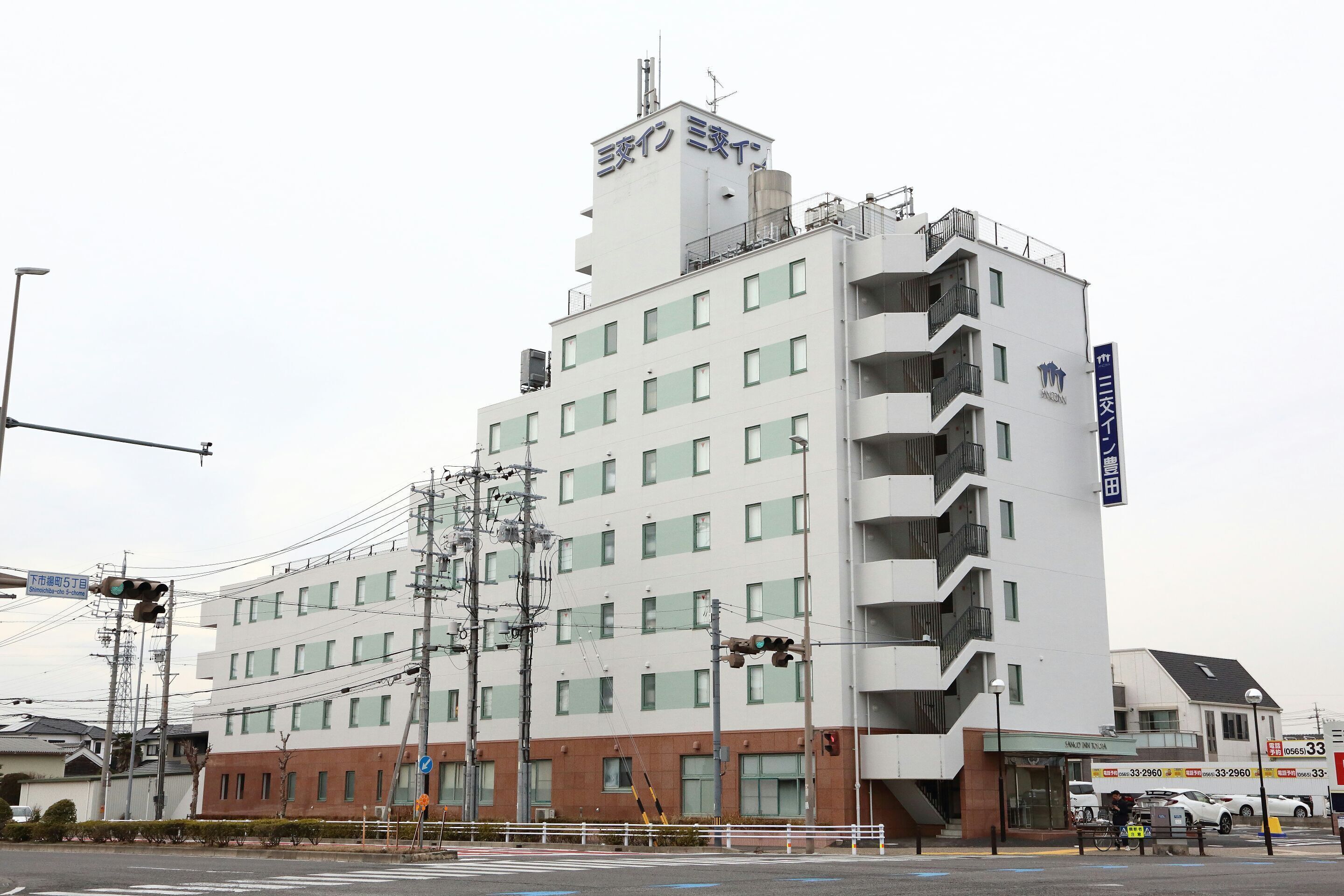 Un hotel de varios pisos con fachada plana, múltiples balcones y un letrero que indica que es un hotel.