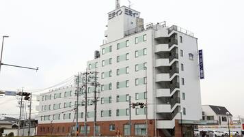 Un hotel de varios pisos con fachada plana, múltiples balcones y un letrero que indica que es un hotel.