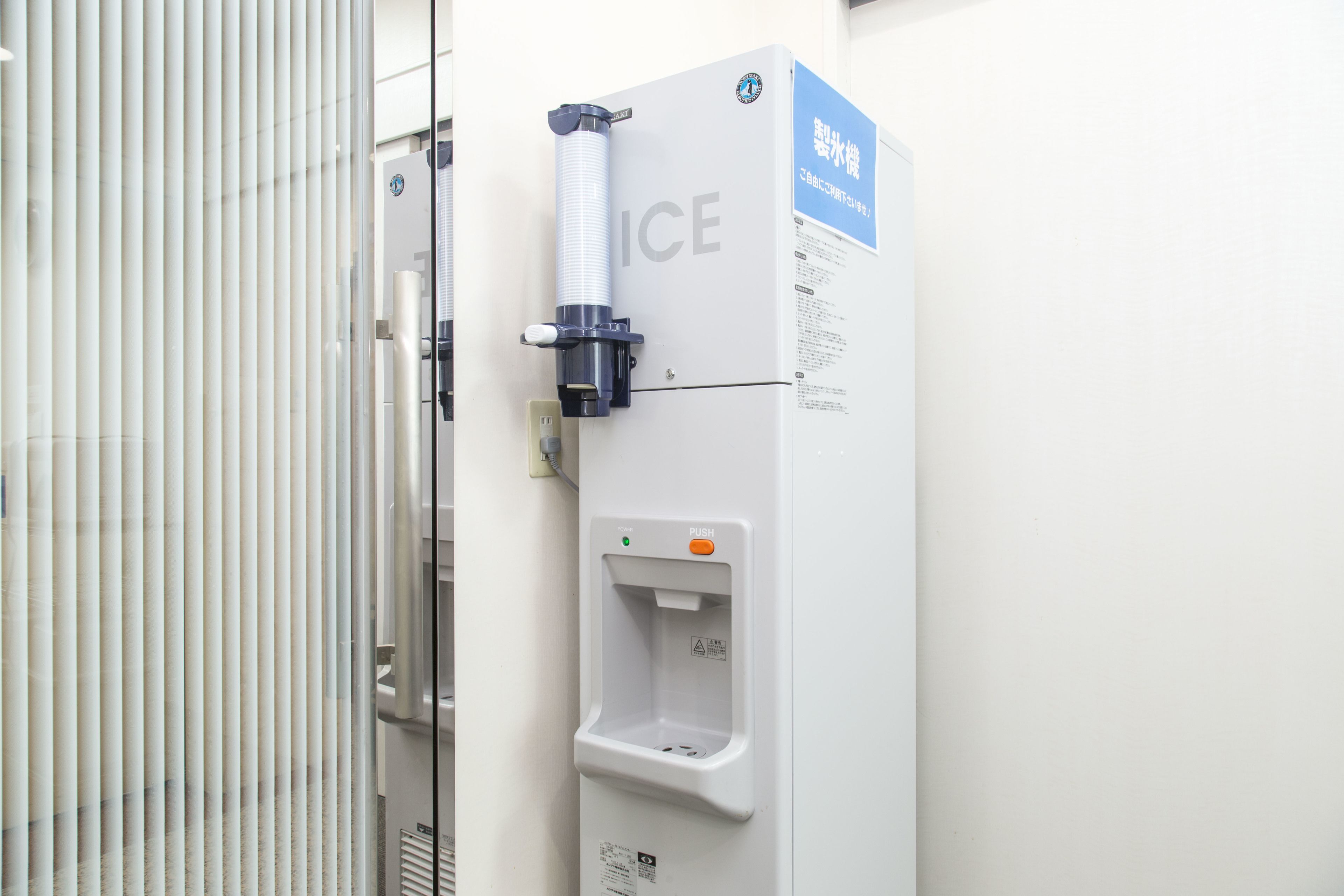 A water dispenser with a push button and a label that reads "ICE".