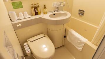 Une salle de bain équipée de toilettes, d’un lavabo et d’un porte-serviettes.