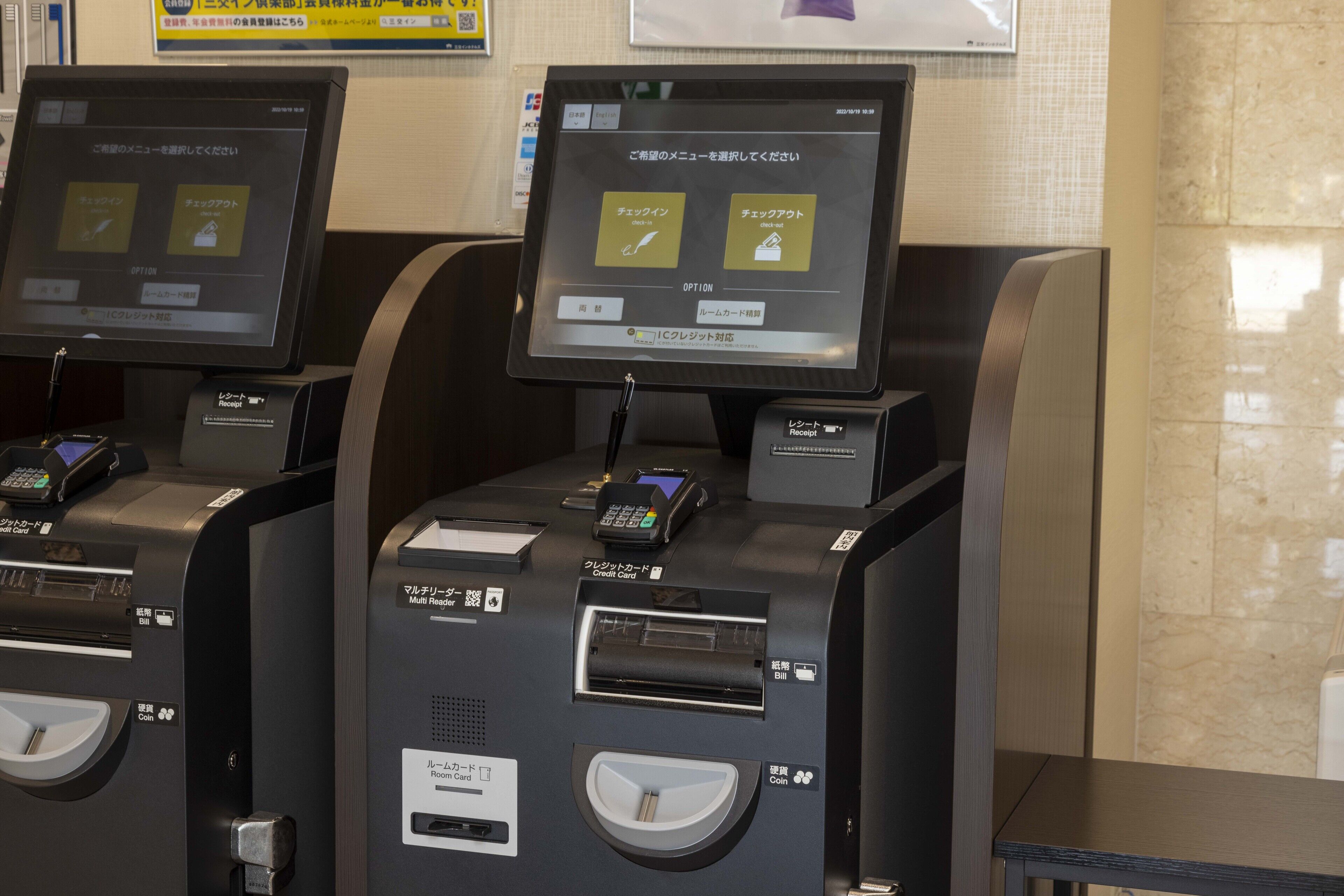 A self-service kiosk with a touchscreen interface for room selection and payment options.