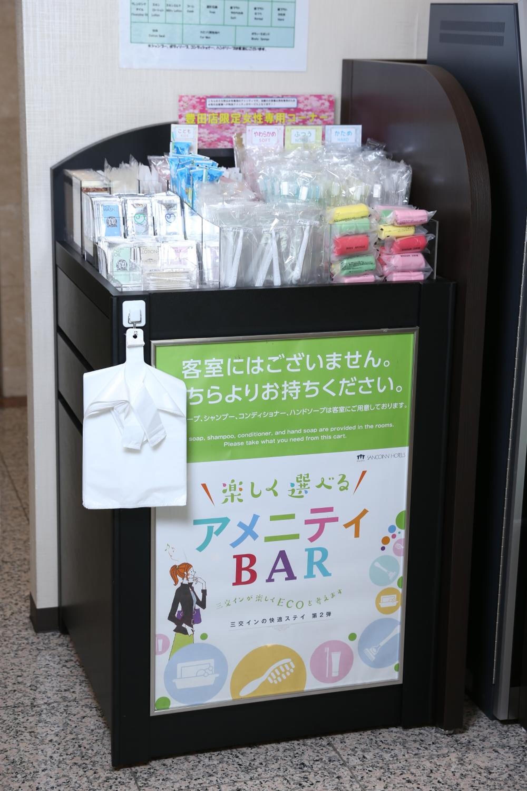 A hotel reception area with a self-service station for toiletries.