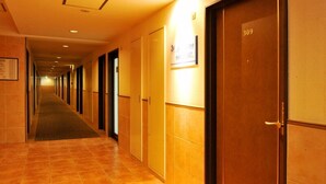 A hotel corridor with doors numbered 309 and 307, a carpeted floor, and a sign indicating room types. - Sanco Inn Toyota (Toyota)