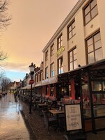 Calle con mesas al aire libre, un restaurante llamado 'Rivers' y un letrero que anuncia 'buffet todo incluido'.
