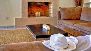 Una sala de estar acogedora con chimenea, un sofá y una mesa de centro con velas.