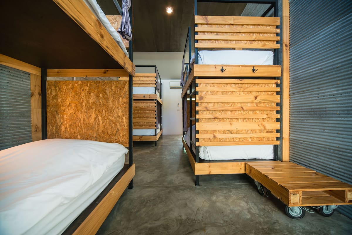 A bunk bed room with a concrete floor and wooden bunk beds.
