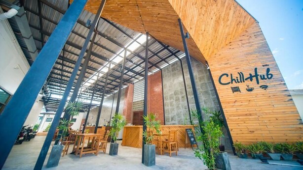 An interior with a wooden wall, a sign reading "ChillHub," and seating arrangements. - ChillHub Hostel (Choeng Thale)