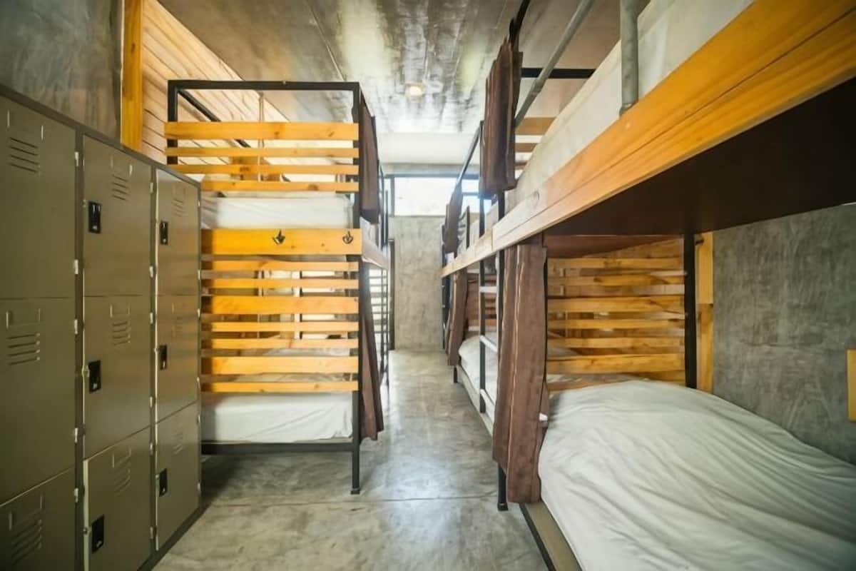A bunk bed room with lockers and a concrete floor.