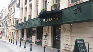 Ein Gebäude mit einer grünen Markise und einem 'WELCOME'-Schild.