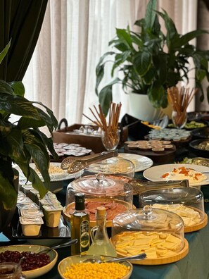 A buffet table with various food items and condiments.