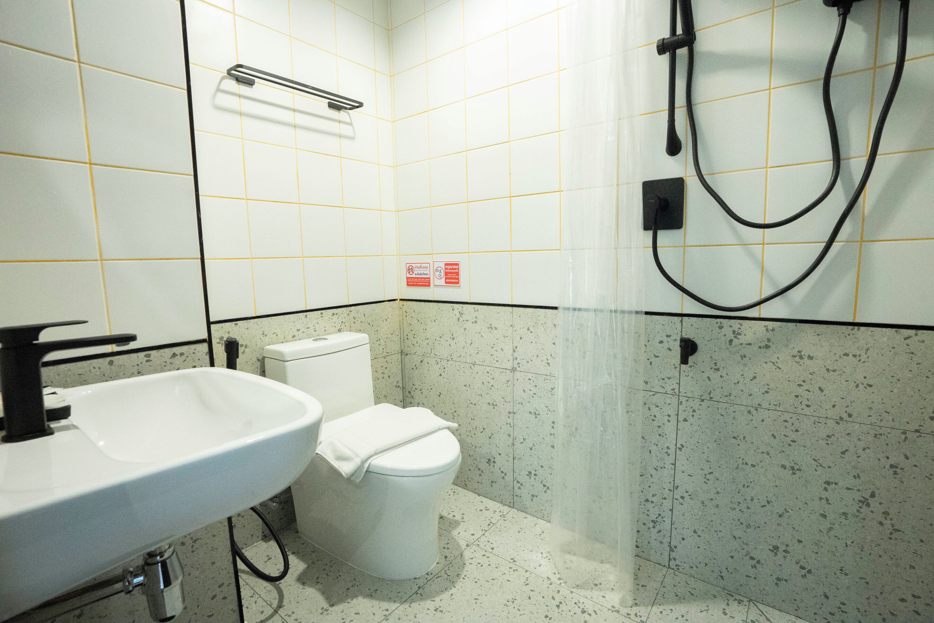 A bathroom with a white sink, toilet, and shower.