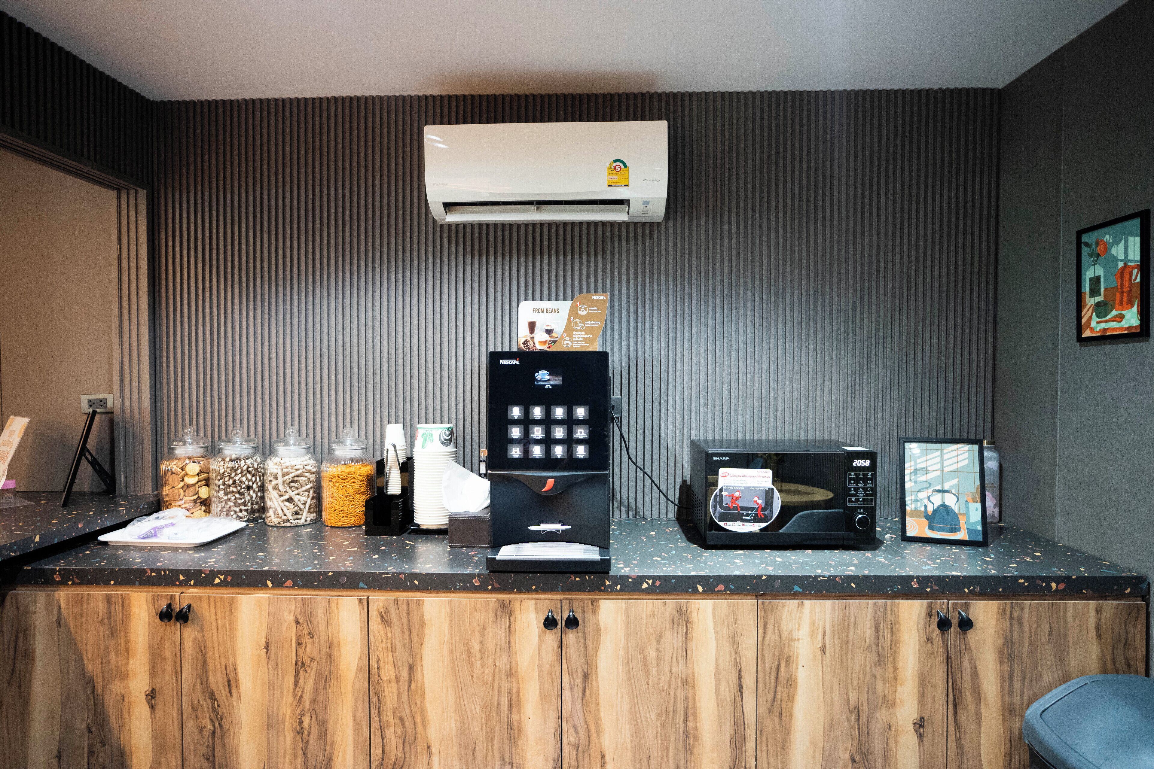 Una kitchenette equipada con cafetera, microondas y frascos para almacenar alimentos.