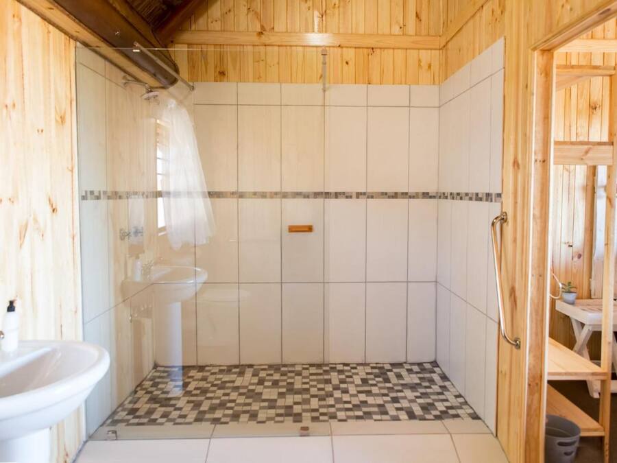 Un bagno con doccia, lavandino e pavimento a scacchi.
