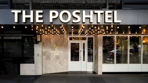 The exterior of The Poshtel, featuring a modern facade with a prominent entrance and illuminated signage. - THE Posh Phayathai (Bangkok)