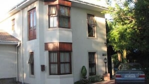 A two-story building with multiple windows and a car parked in front. - Magnolia Place Guest House (Stellenbosch)